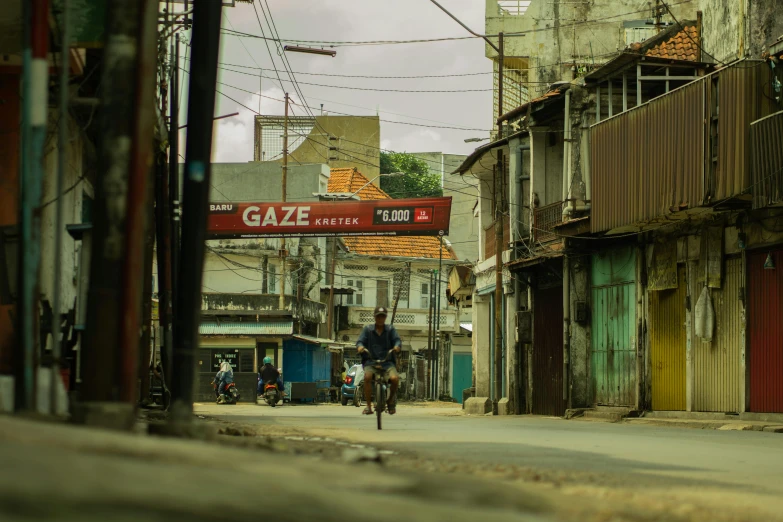 a man riding a bike down a street in an old world