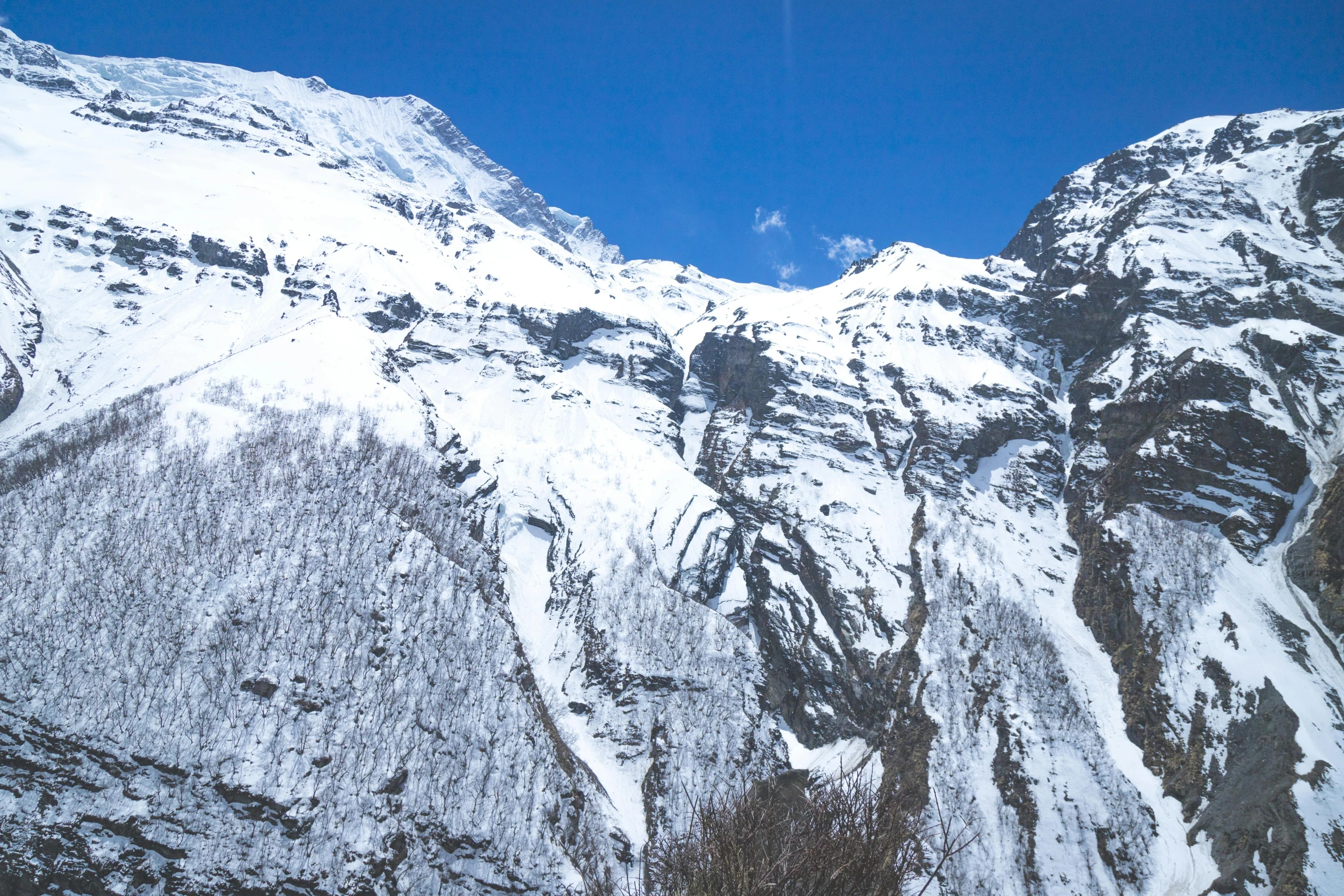 a large mountain with snow and rocks on the sides