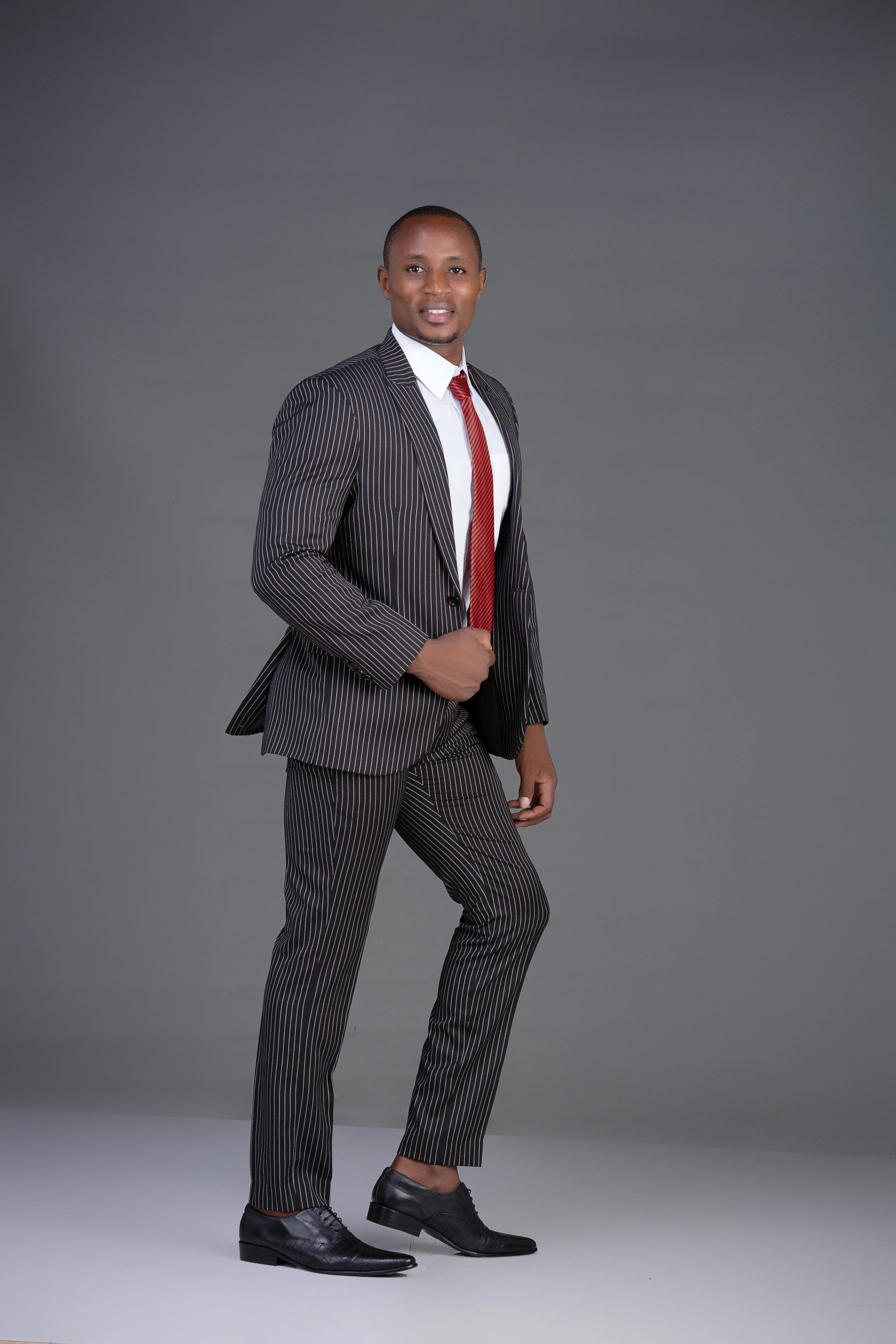 a man dressed in a suit with no shoes posing for a po