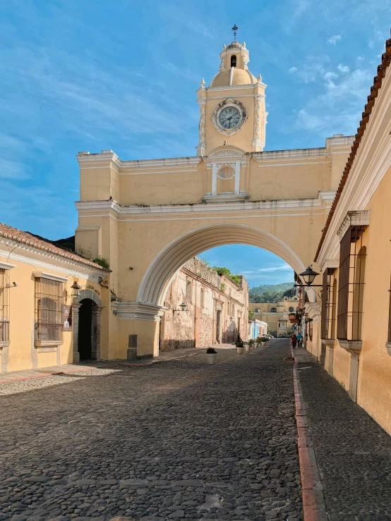 a clock tower towering over an arch and building