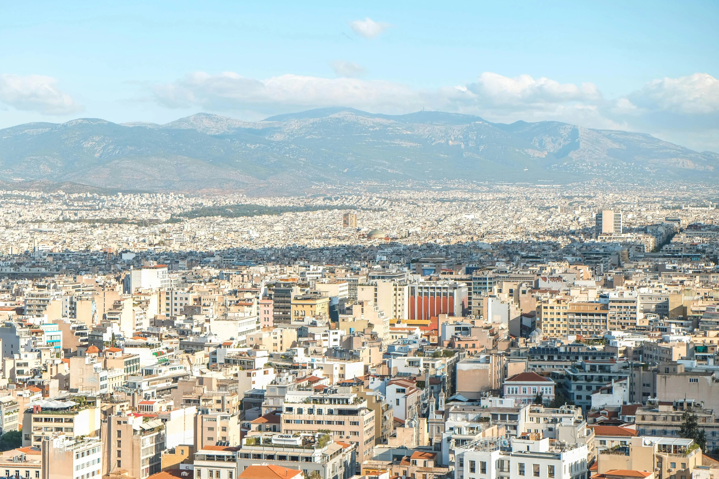 an aerial view of a city, with mountains and hills in the background