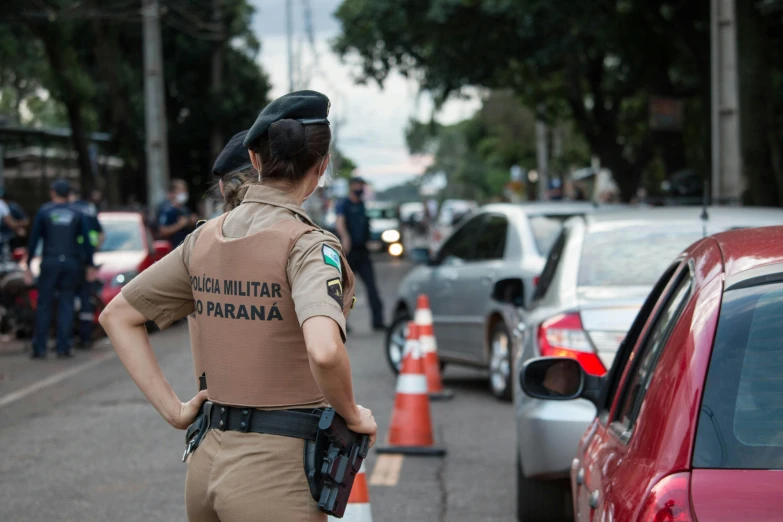 an officer is standing by the side of a road