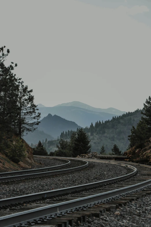 railroad track on the ground with mountains in the background