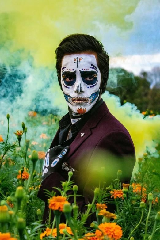 a man in a field of flowers with his face painted like a skeleton