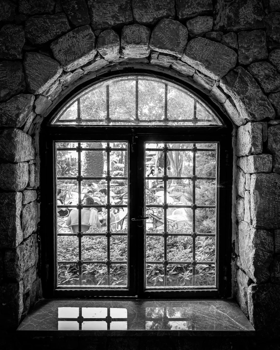 black and white pograph of an open window in a stone building