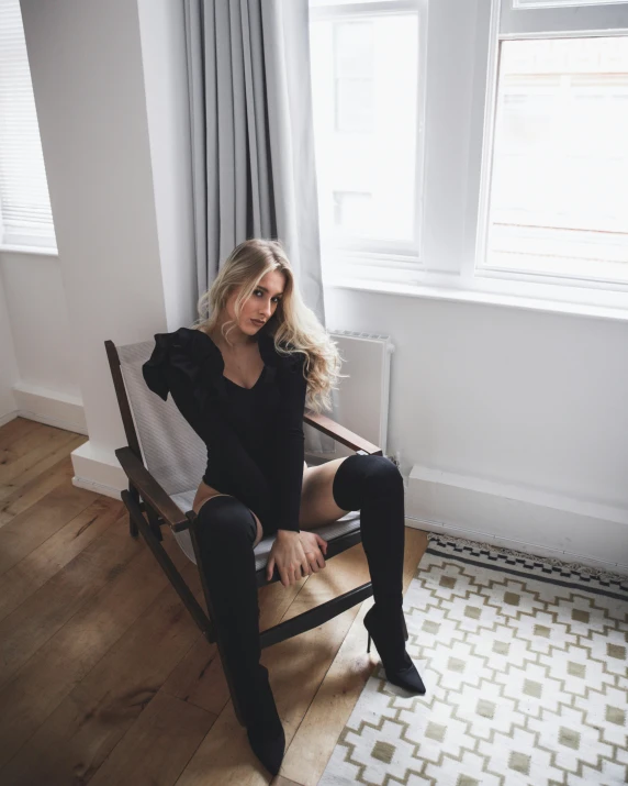 a woman sitting in a chair near a window