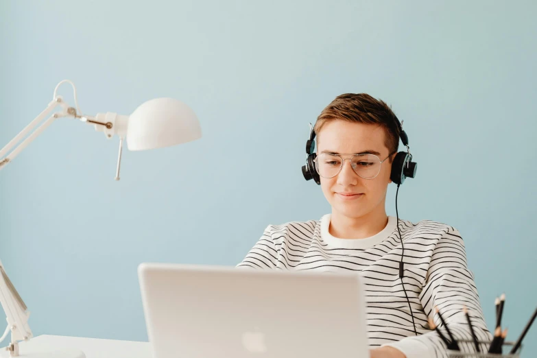 the woman is listening to music using her laptop