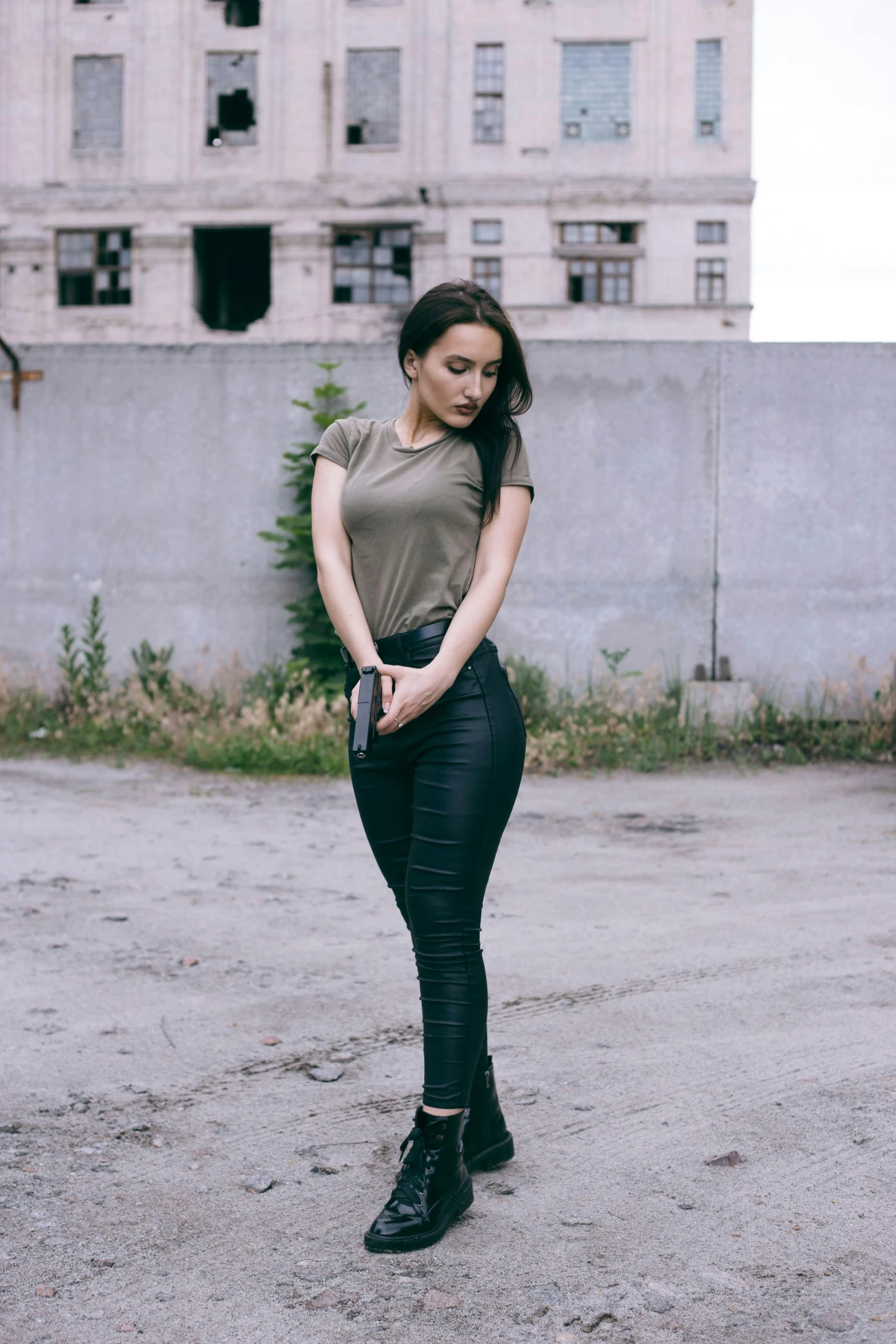 young woman dressed in black jeans, army shirt and black boots