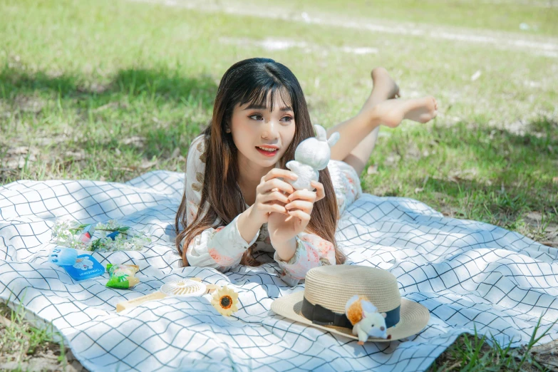 a woman laying on a blanket holding a toy gun