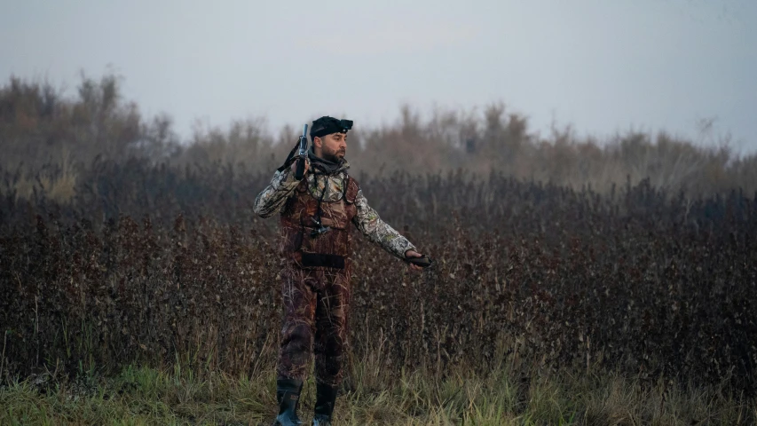 a man in camouflage is standing on the side of the road