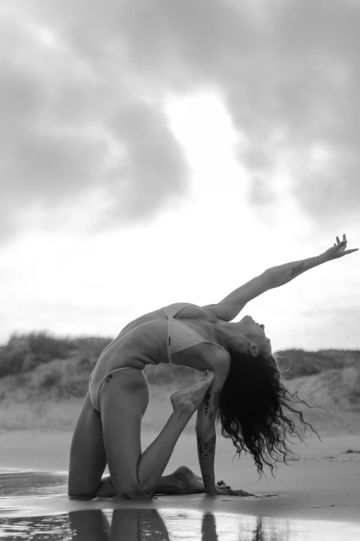 a woman leaning on her  with her hands on the ground by the water