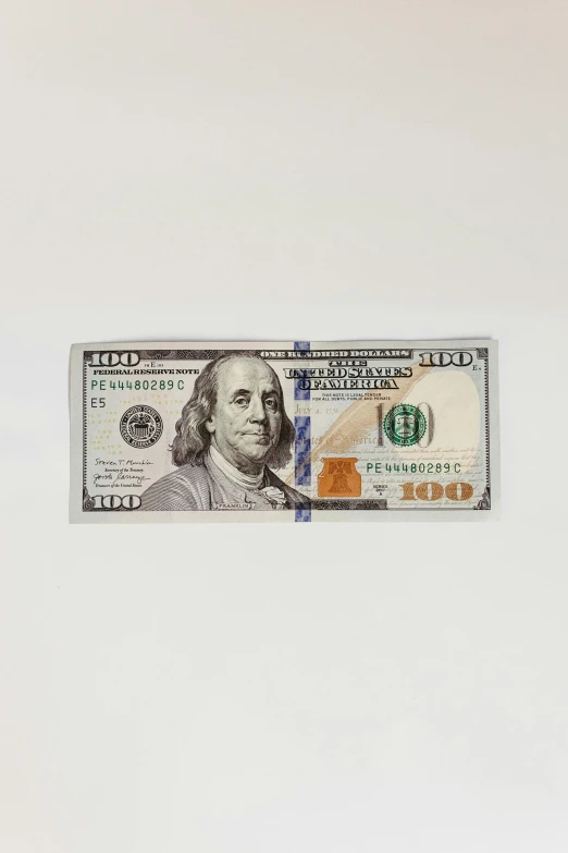 a twenty dollar bill on display against a white background