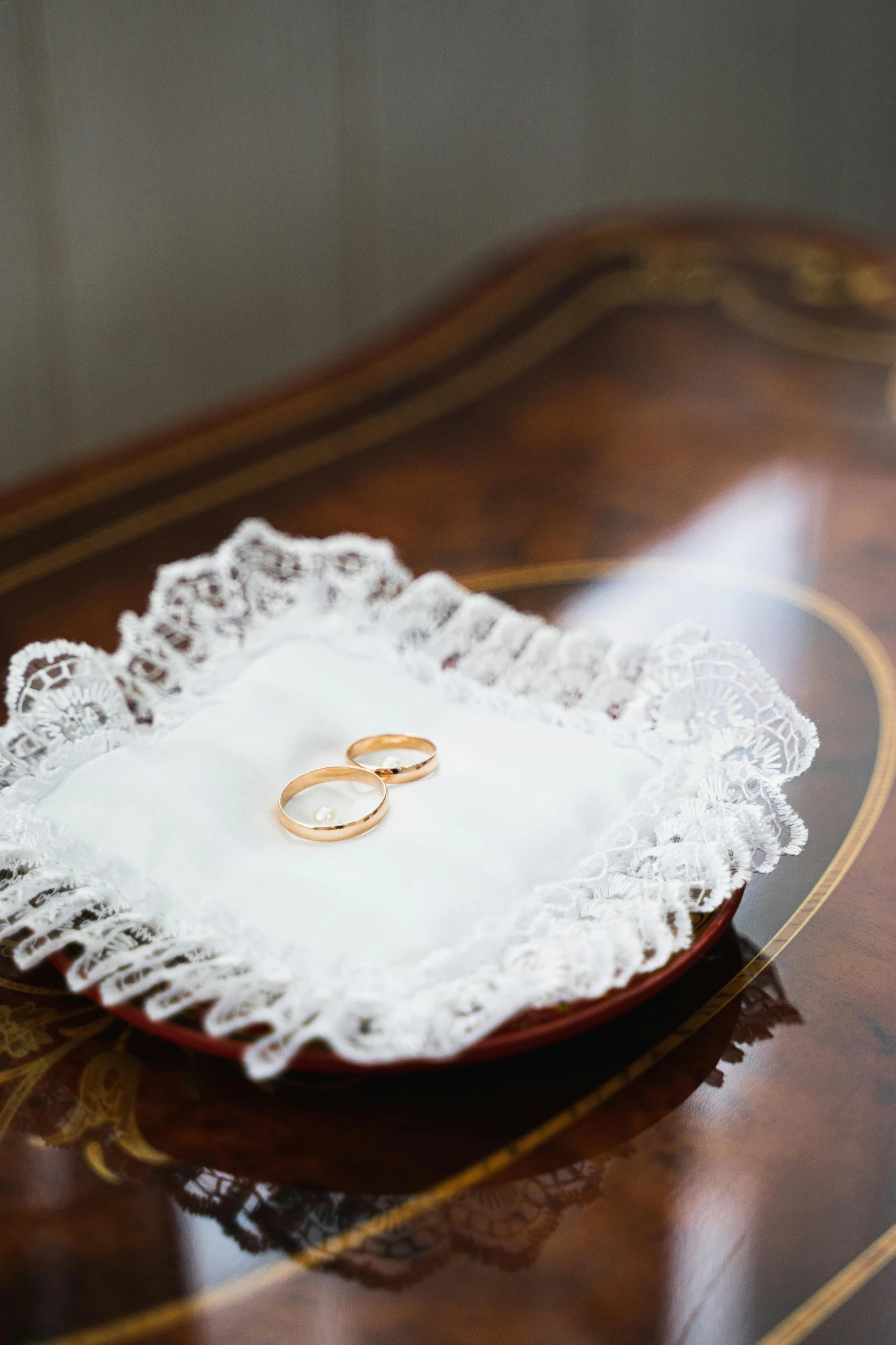 two rings are sitting on a decorative doily