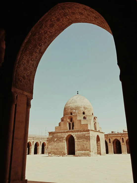 an arch leads into an old building with a domed dome