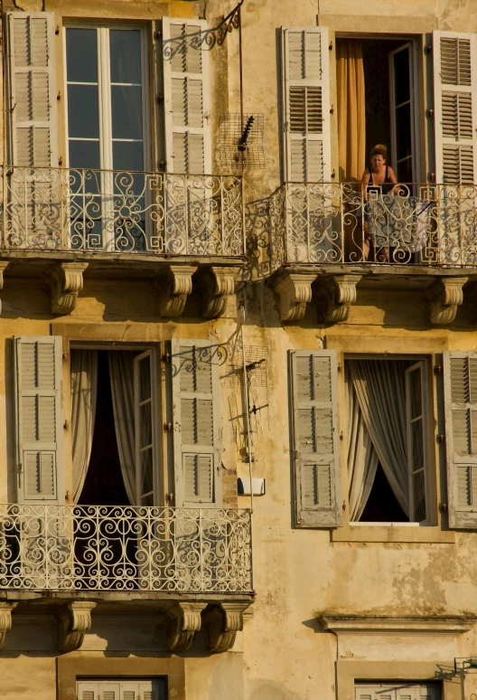 two windows that have iron bars and balconies