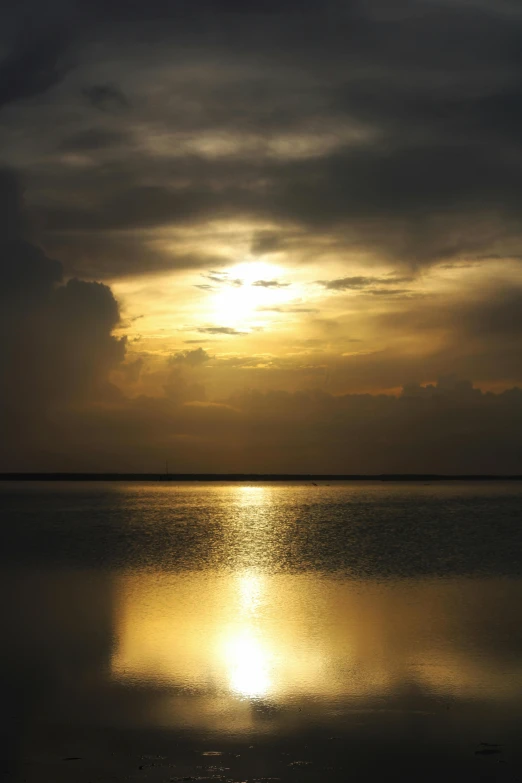 the setting sun reflecting on a calm lake