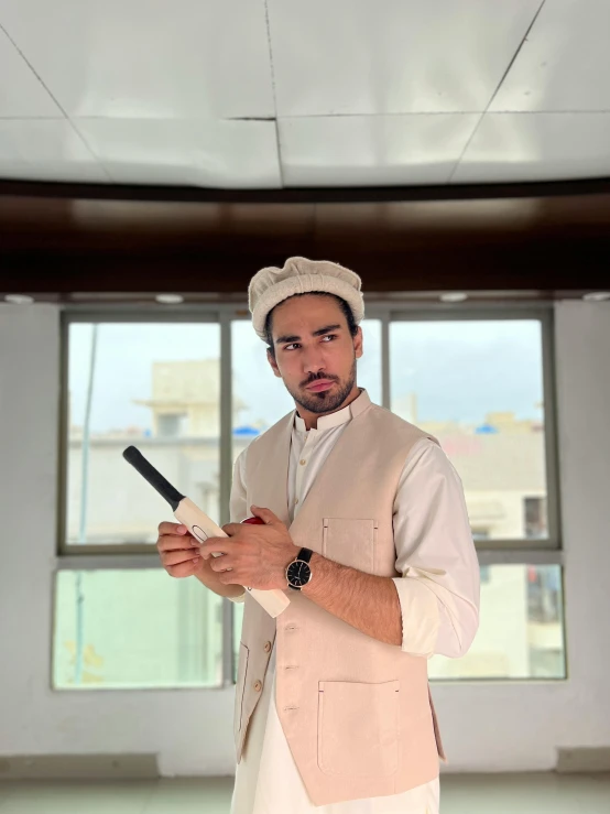 a man wearing a white top hat and vest in a white room