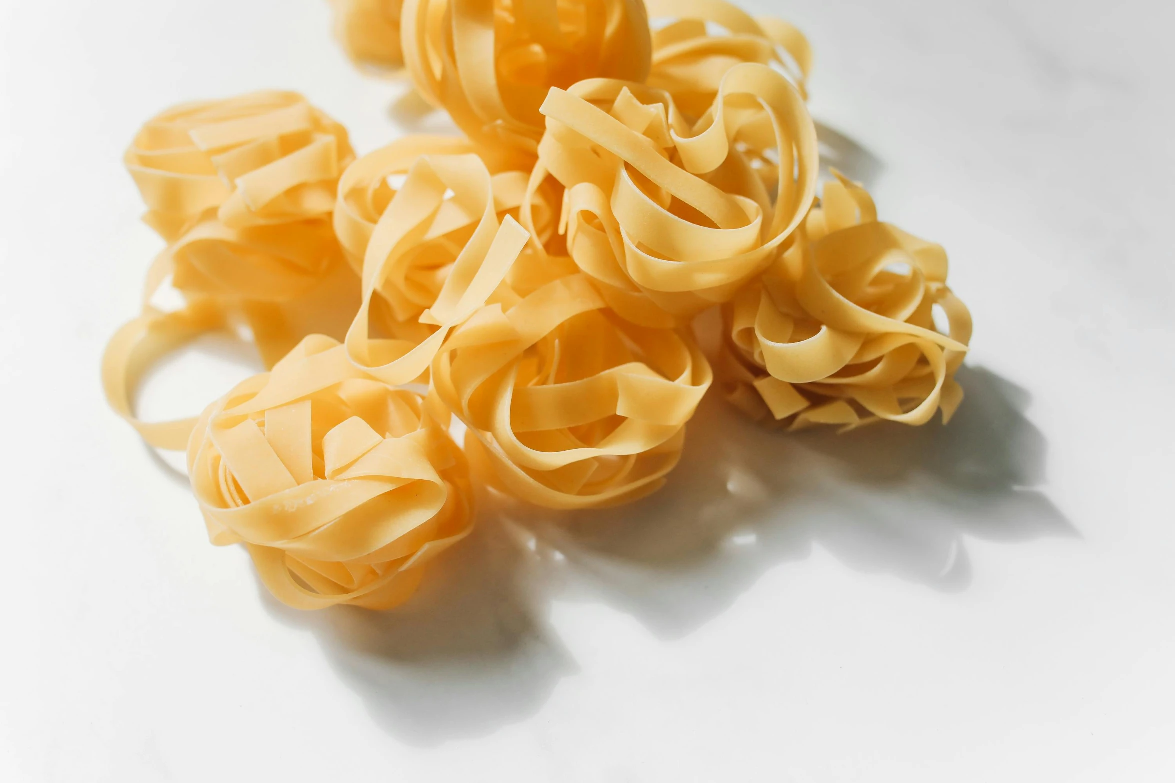 four pasta bows are on a white surface