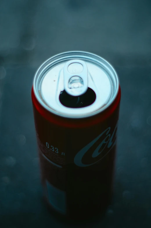 can of soda on a table in dark room