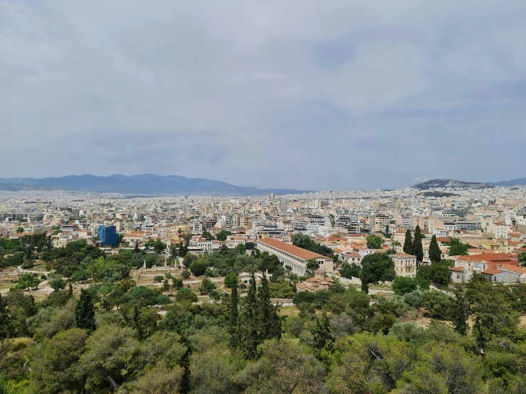 the skyline of a city with trees, bushes and hills