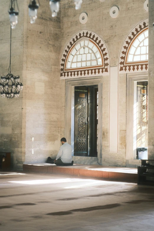 a man sitting on the ground in a room with two doors