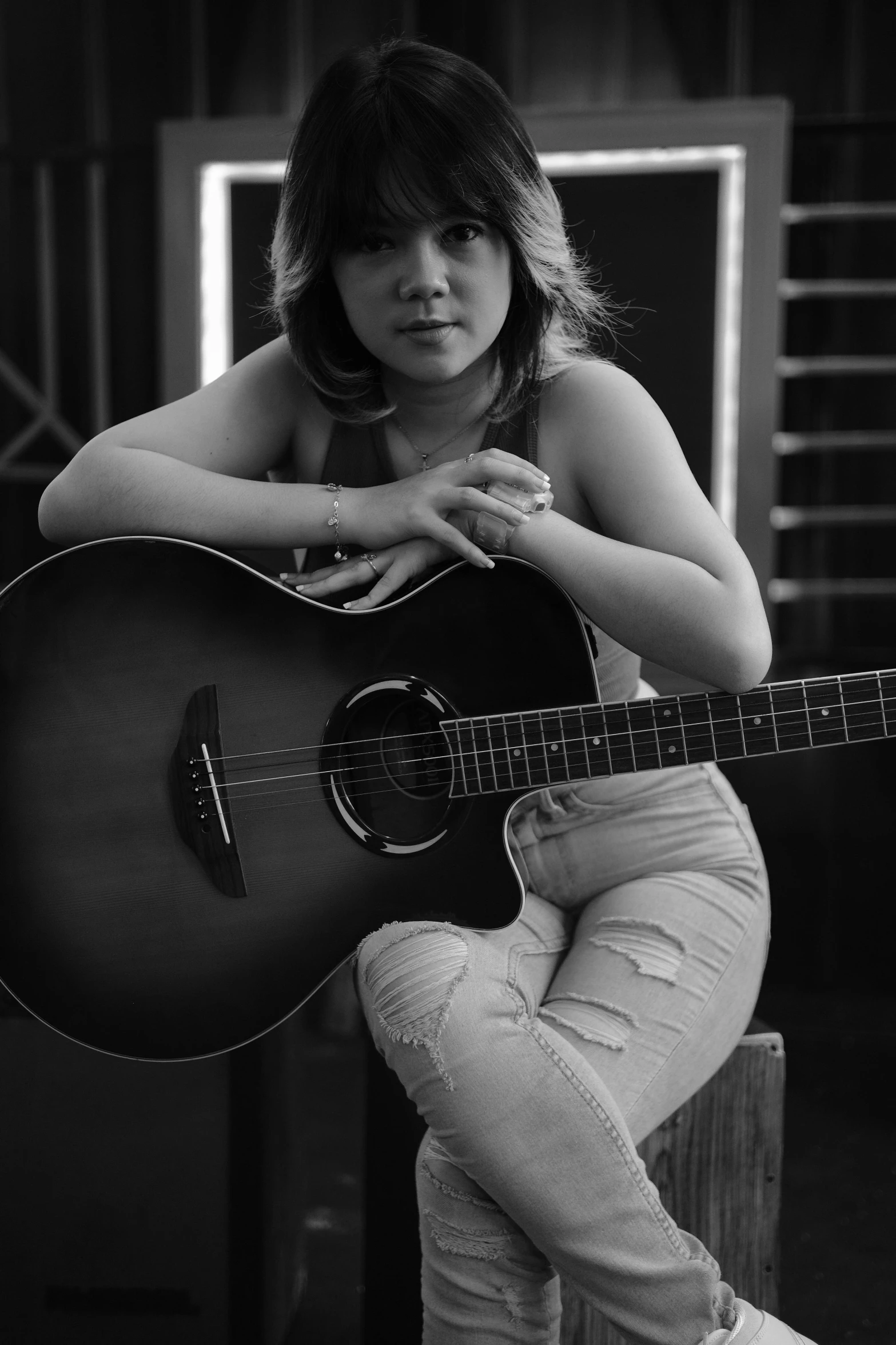 a woman that is sitting down with a guitar