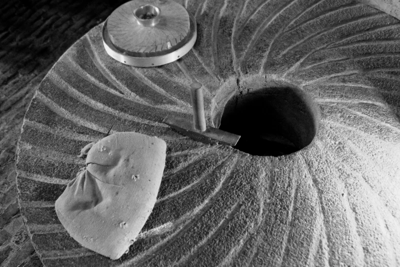 a knife laying on top of a sand covered round base