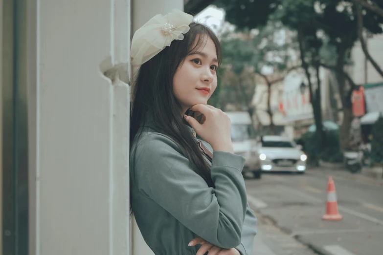 a woman posing by a building on the side walk