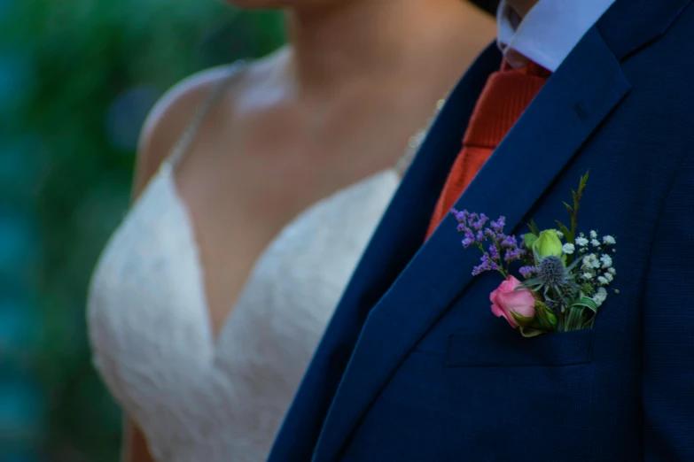 the man in the blue suit is holding a pink rose