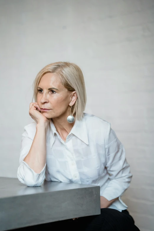 a woman in white shirt sitting at a table