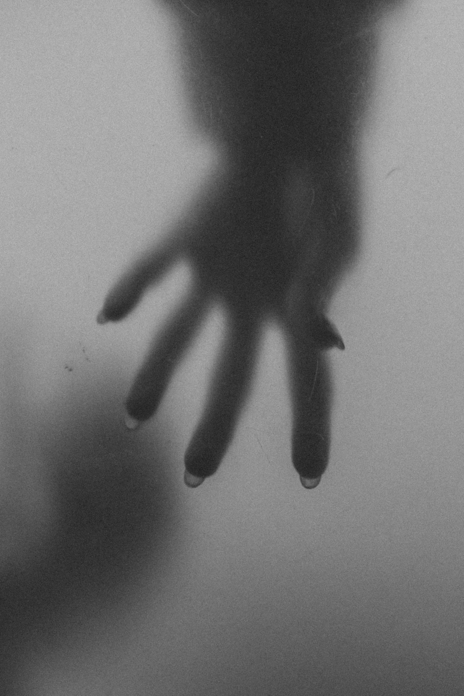 blurry image of hand of a person reaching out of the mist