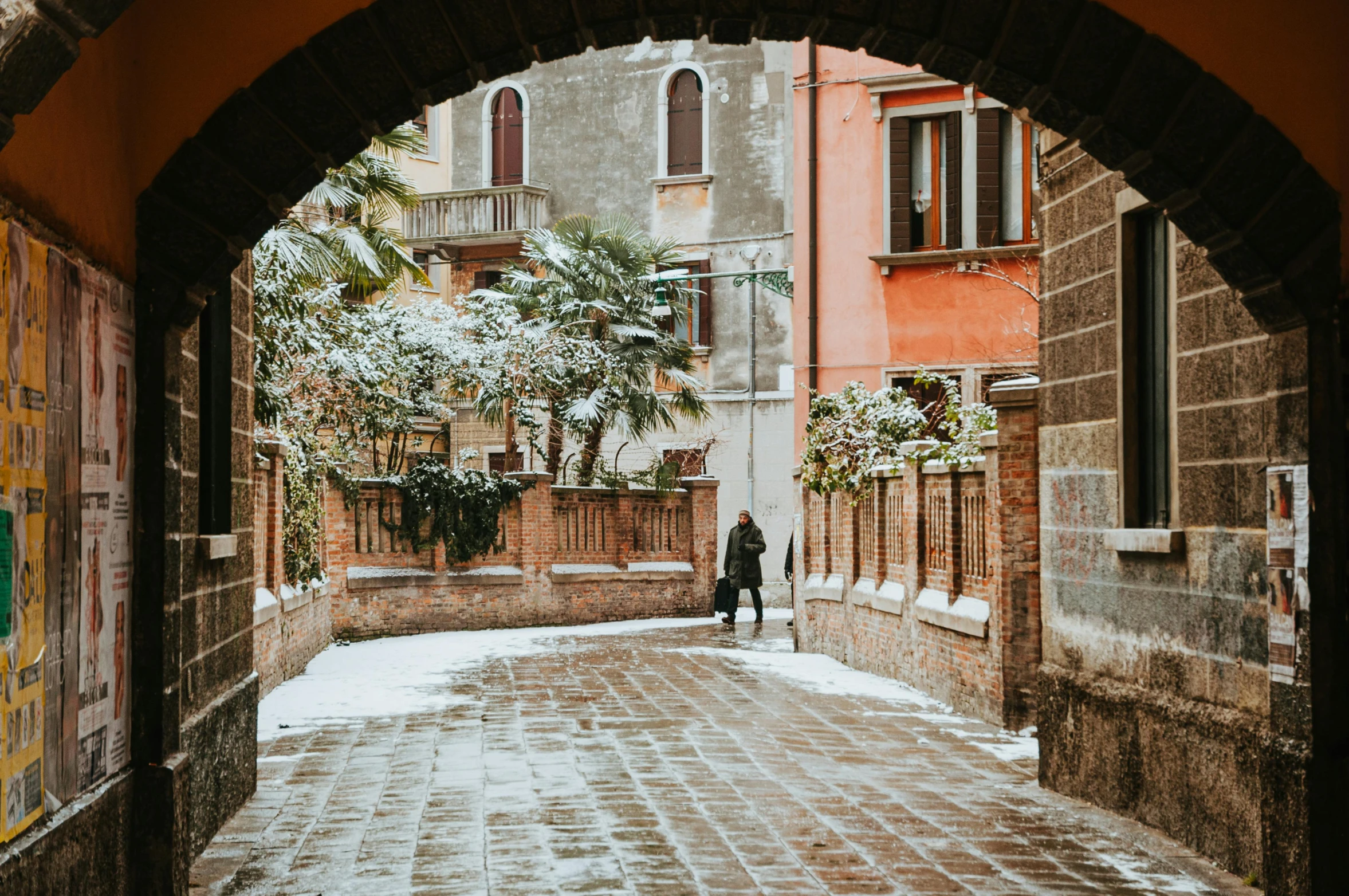 a brick walkway is in between two tall buildings