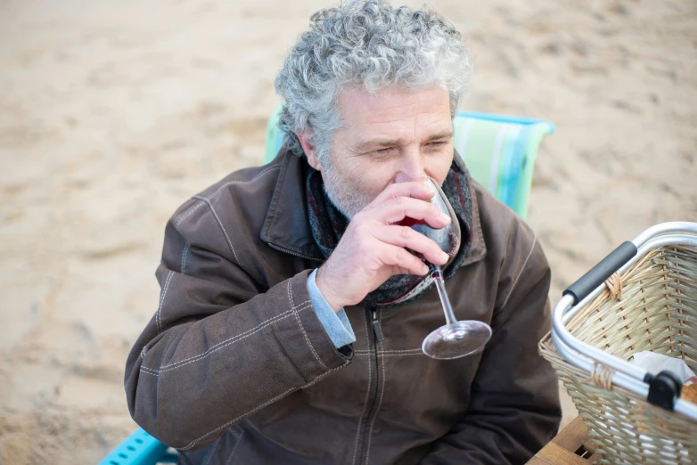 a man is holding a glass and looking away from the camera