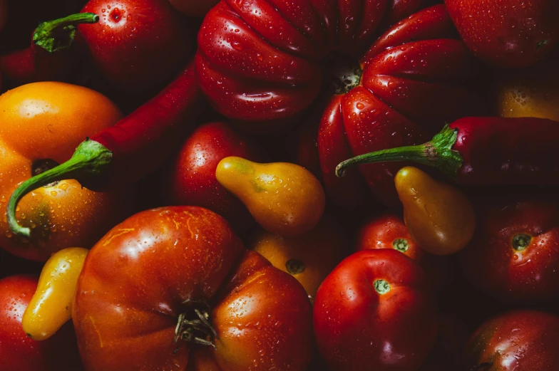 lots of small red peppers next to big yellow peppers