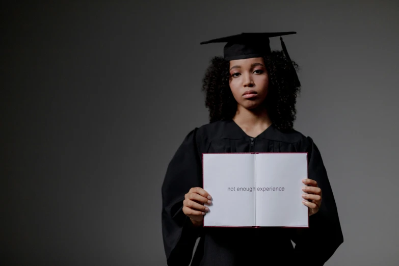 a woman holding up a sign that reads she is a graduate