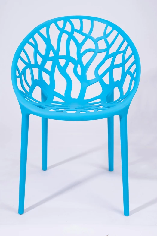 an outdoor table with a blue plastic chair with tree design on it