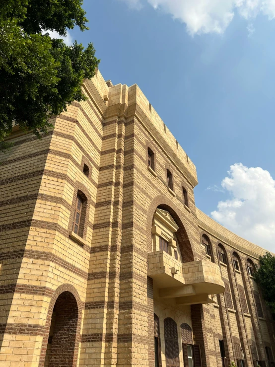 a very large brick building sitting below a tree