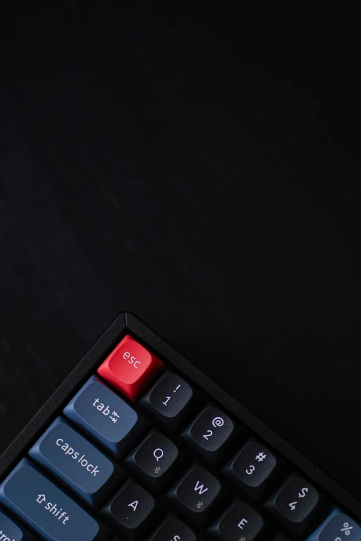 the keyboard is sitting on the table with some red keys