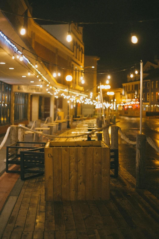 a night time view of a street with lights hanging