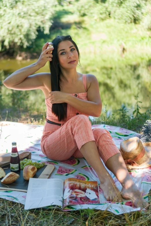 a girl is sitting on a blanket outdoors