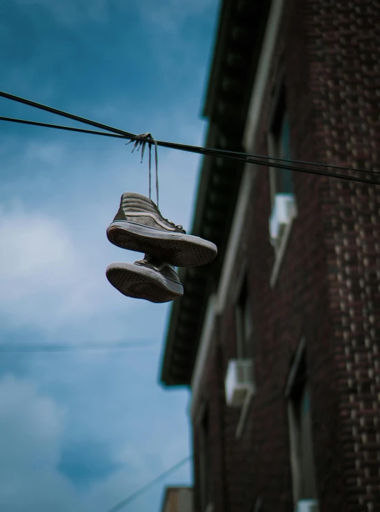 two shoes hanging off the power line in front of a building