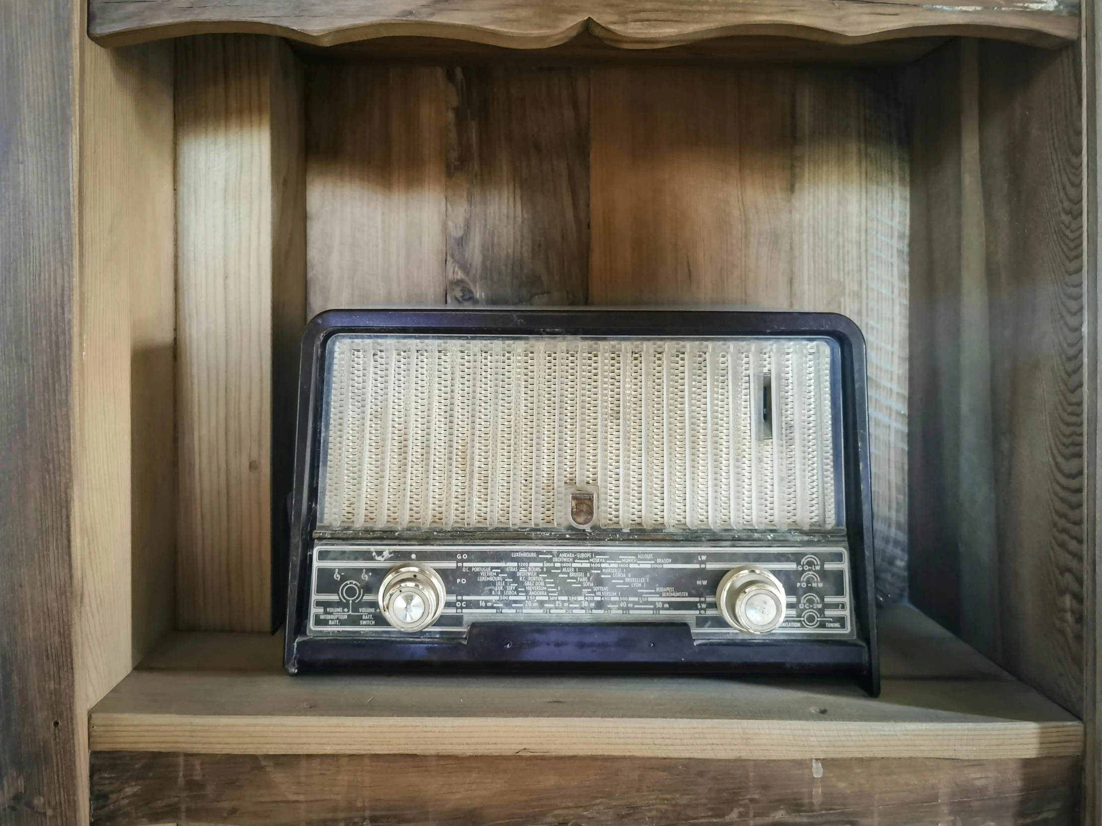 an old radio sitting in a book shelf