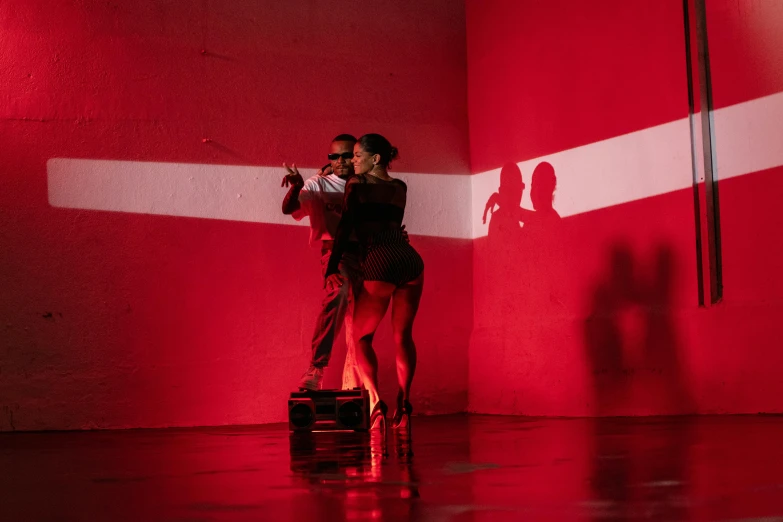 a young couple dances together in a dimly lit dance studio