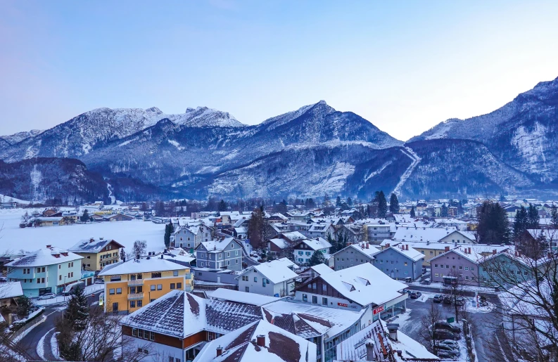 the view of town below snow covered mountains