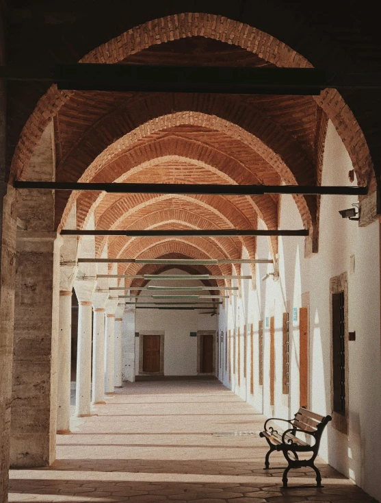 an empty hallway with a bench sitting beneath it