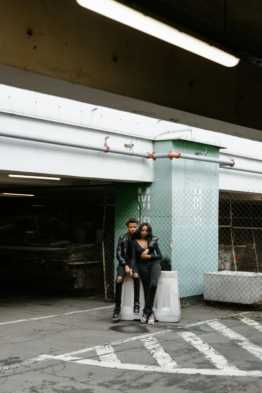 two women sitting next to each other by a parking garage