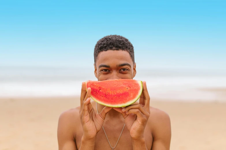 a man holds a slice of watermelon over his eyes