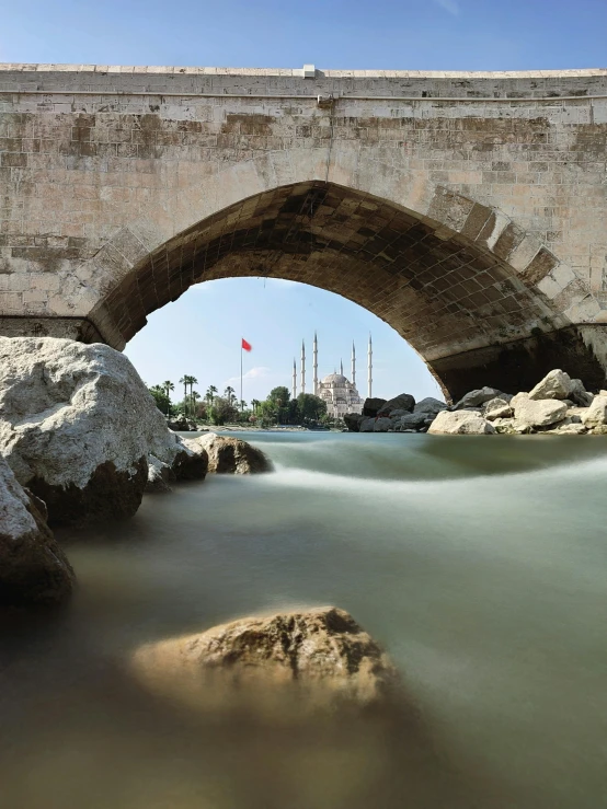 a stone bridge over a river surrounded by rocks