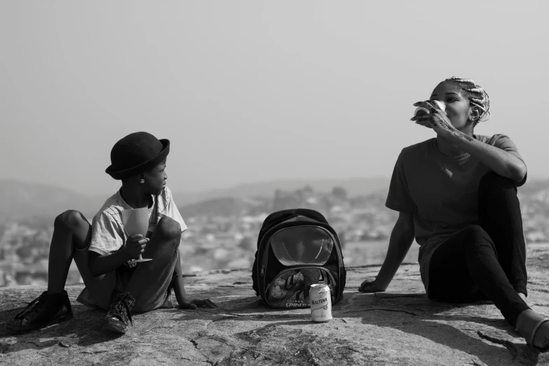 a couple of people sitting on top of a rock