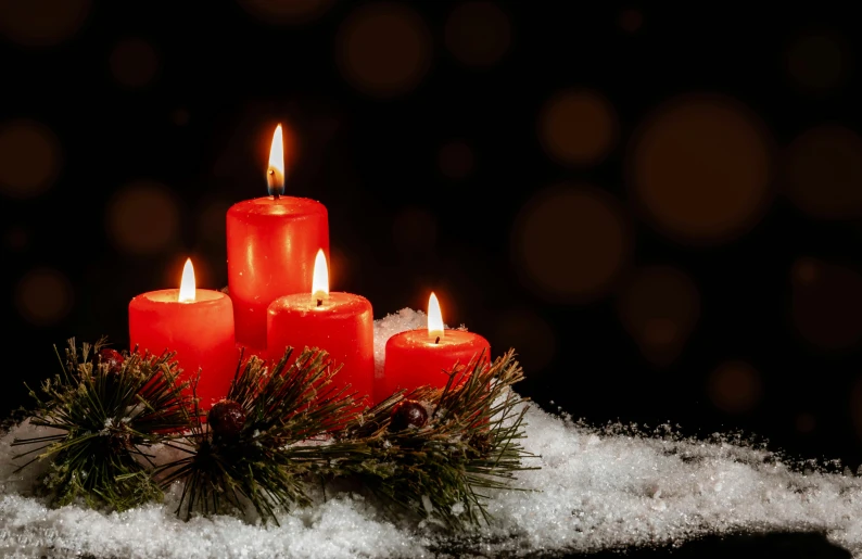 a group of red candles sit on some snow